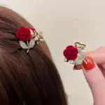 Pair of wine red velvet rose mini hair claw clips with rhinestone leaf detail worn in brown hair
