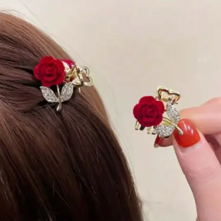 Pair of wine red velvet rose mini hair claw clips with rhinestone leaf detail worn in brown hair
