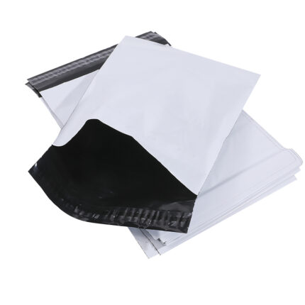 Stack of white black-lined self-seal plastic mailing courier bags for apparel and item shipping packaging
