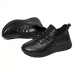 Pair of slip-on lace-up black genuine leather women casual sneakers with flexible cushioned sole, designed for long-hour work, walking and daily commuting wear