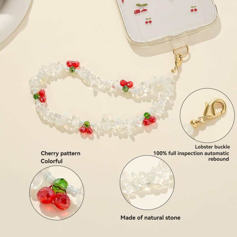 White natural stone beaded phone wrist strap decorated with red cherry ornaments and golden lobster clasp, used as an anti-lost decorative hand chain for mobile phones in daily use.
